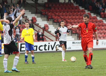 Referee Steve Conroy points to the penalty spot